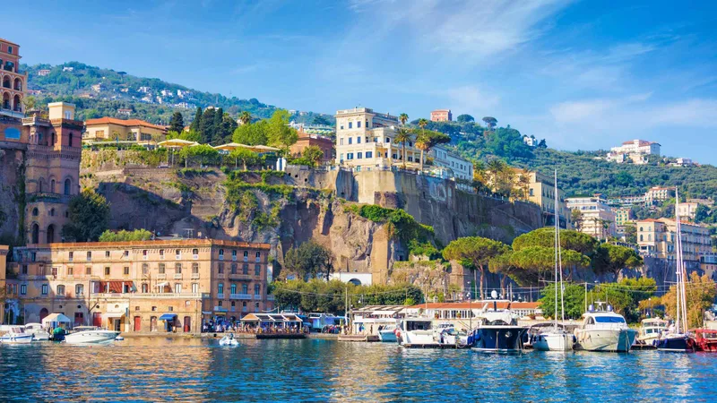 Sorrento harbour and cliffside hotels above the marina, the afternoon stop on Pompeii tours from Rome that add the Amalfi Coast, Italy
