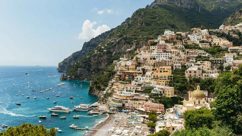 Positano houses stacked above the beach and moored boats, the coastal stop on Pompeii tours from Rome that include the Amalfi Coast, Italy